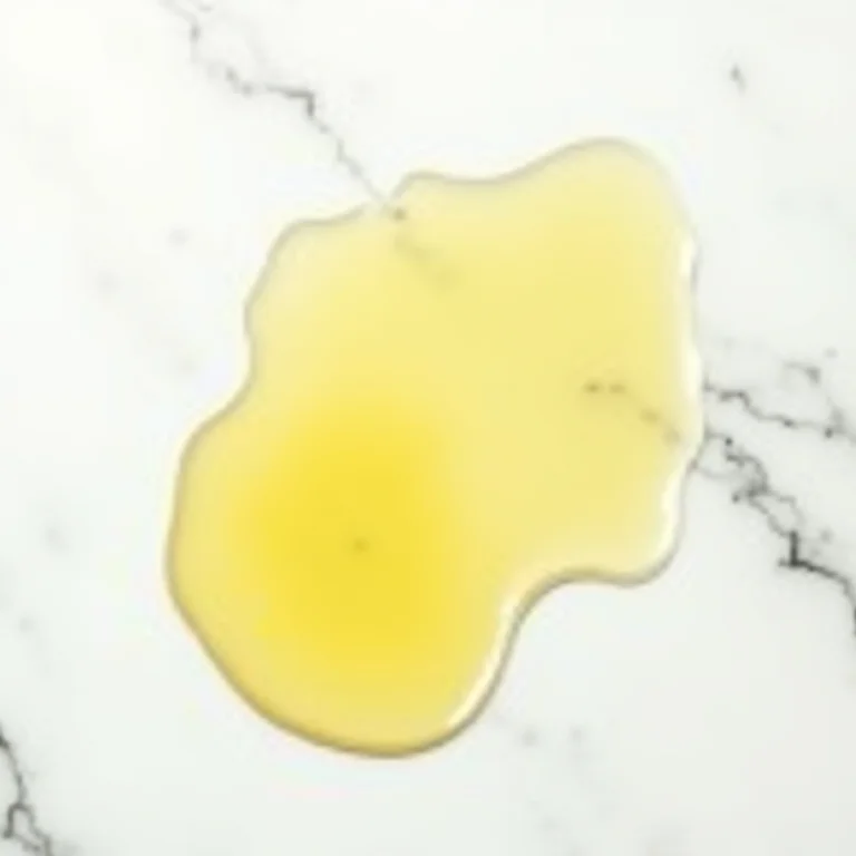 Diferentes tipos de óleo derramados sobre mármore branco